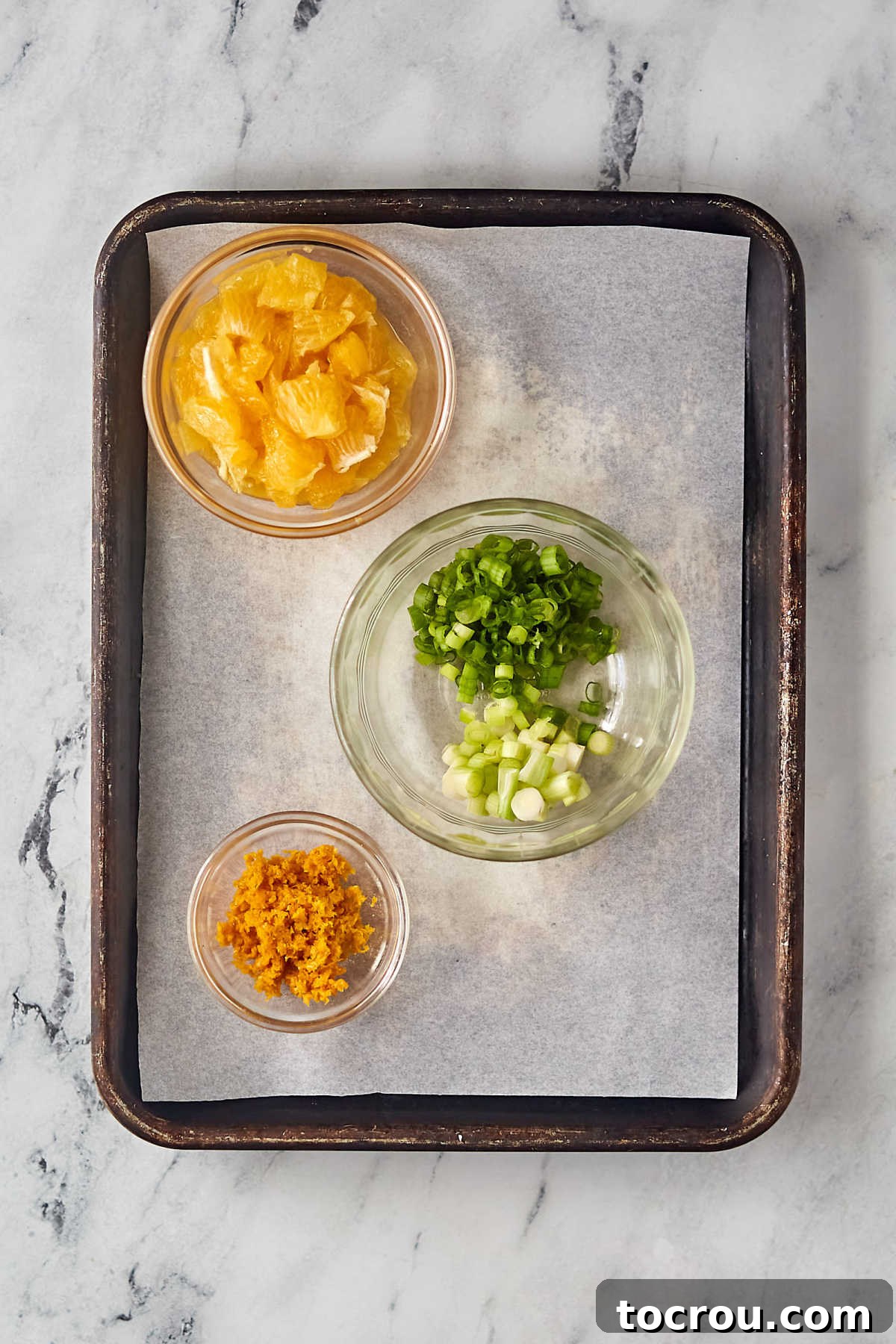 Prepped Orange and Green Onions Closely arranged prepped ingredients: segmented orange sections, thinly sliced green onions (white and green parts separated), and fragrant orange zest, ready for the rice pilaf preparation.