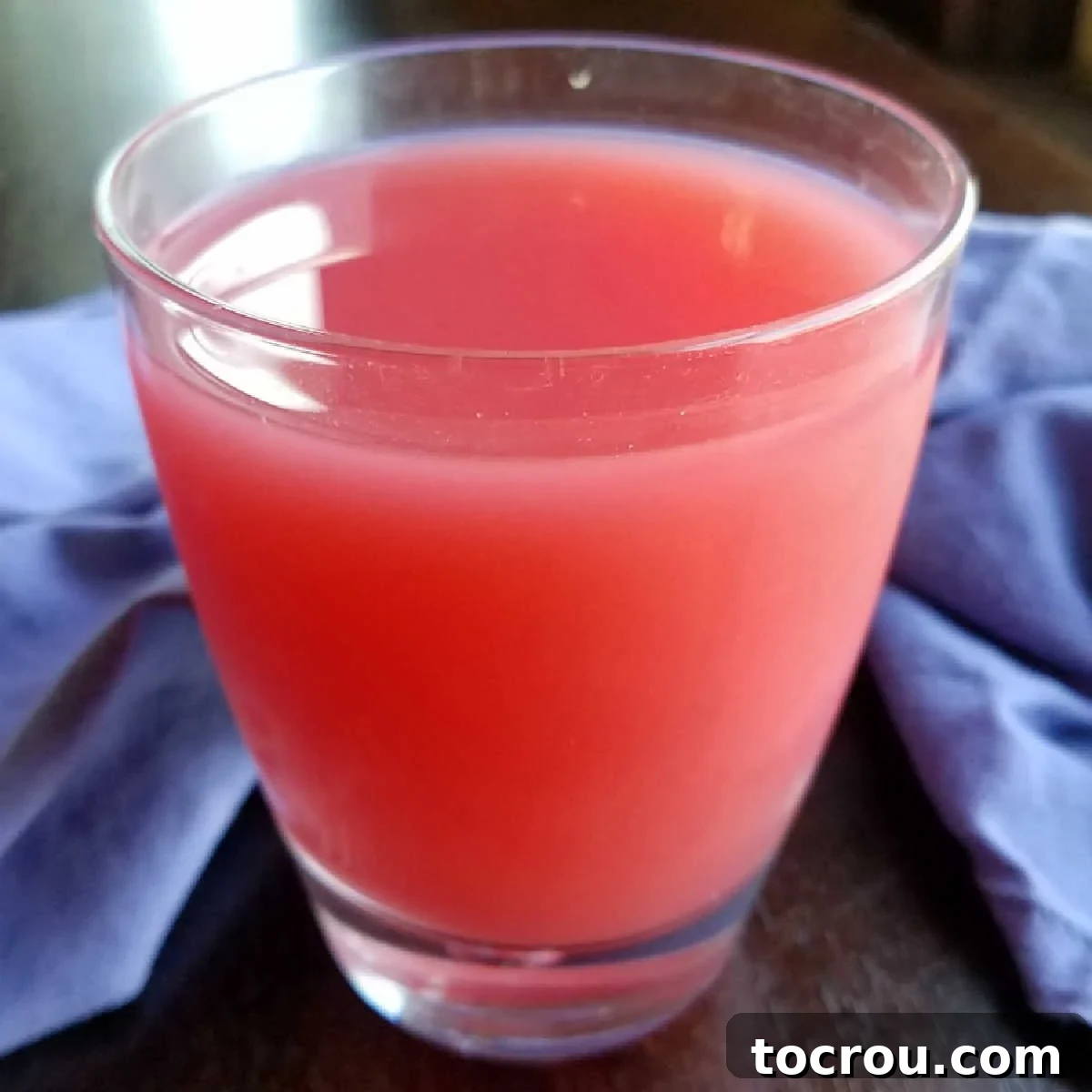 A refreshing glass of pink sherbet punch, garnished and ready to be enjoyed.