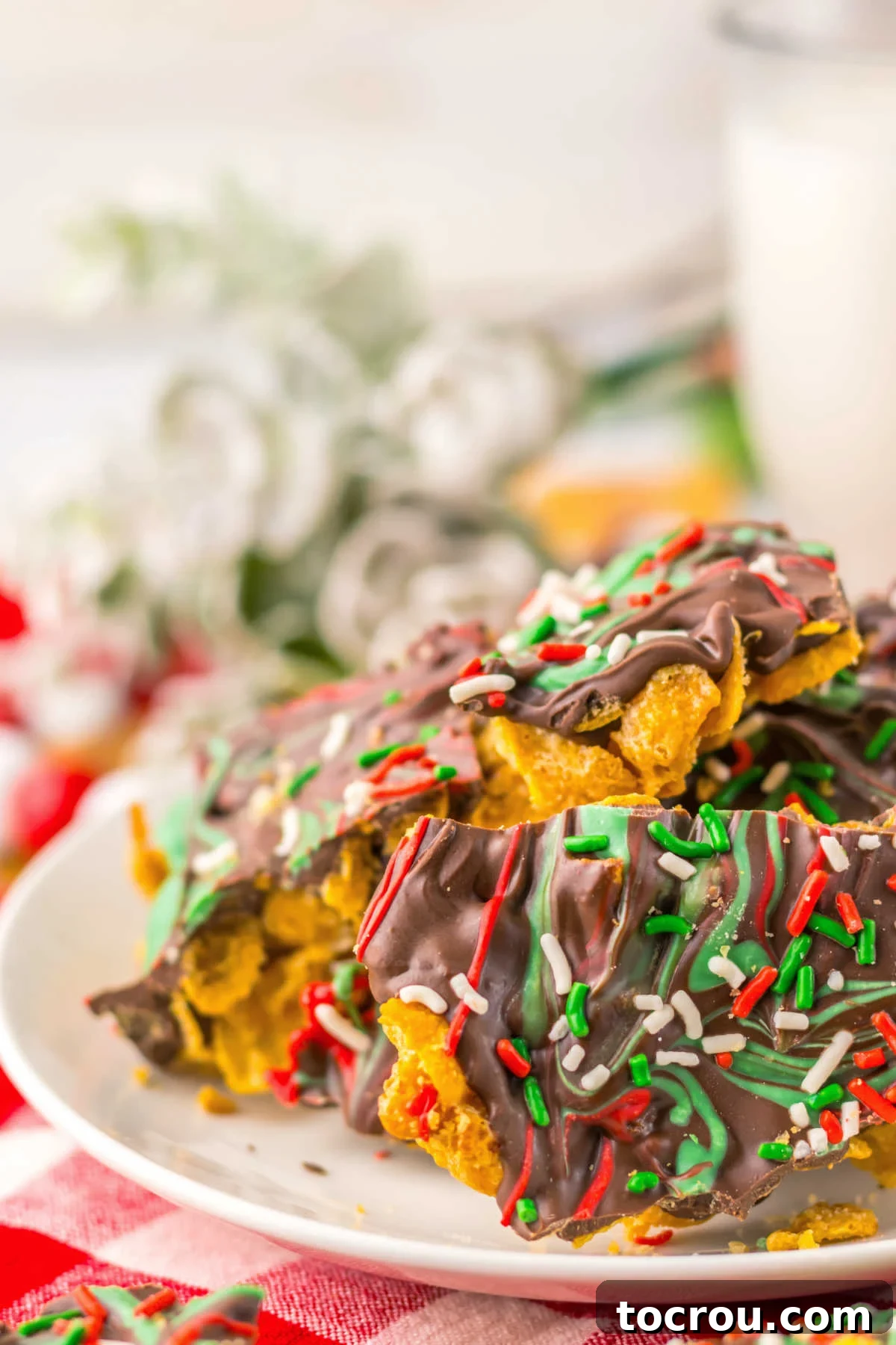 A close-up shot of the cornflake brittle, clearly showing the distinct layers: a golden, crunchy caramelized cornflake base beneath a smooth, rich chocolate topping.