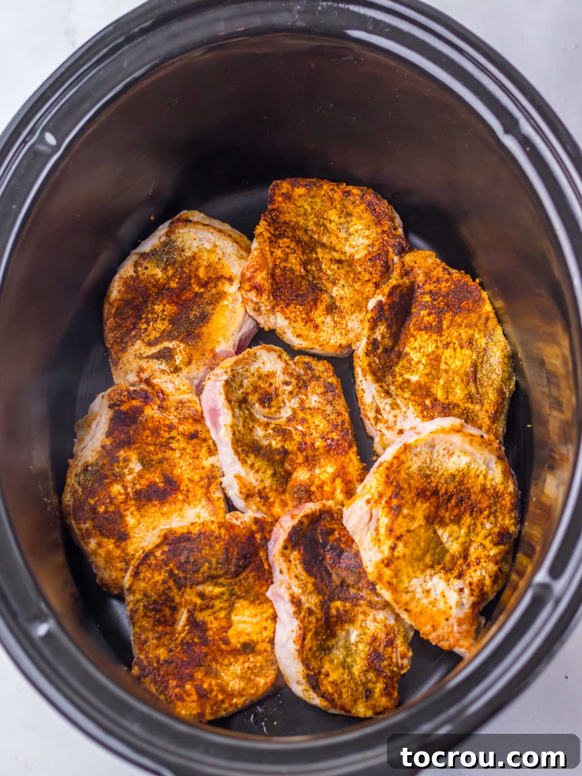 Seasoned pork chops in a crock pot. 