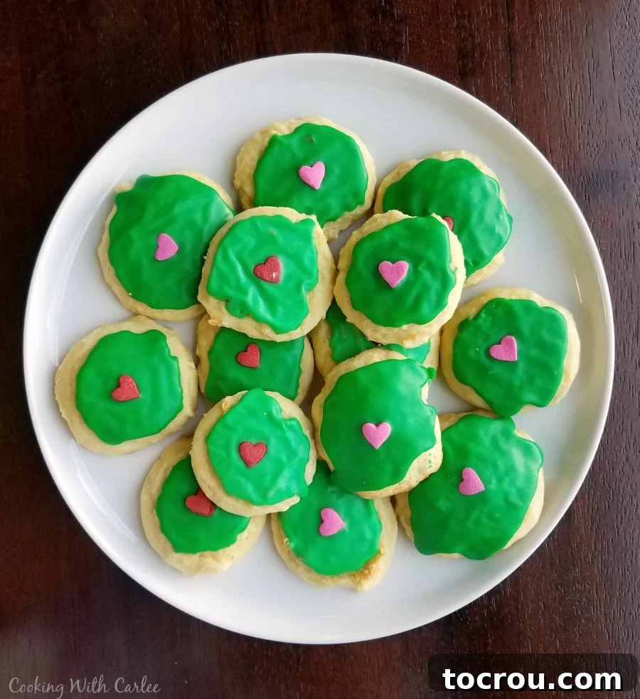 Grinch Cookies with Hearts Sour cream cookies with bright green icing and candy hearts on top, designed as 'Grinch Cookies' for a Dr. Seuss party.