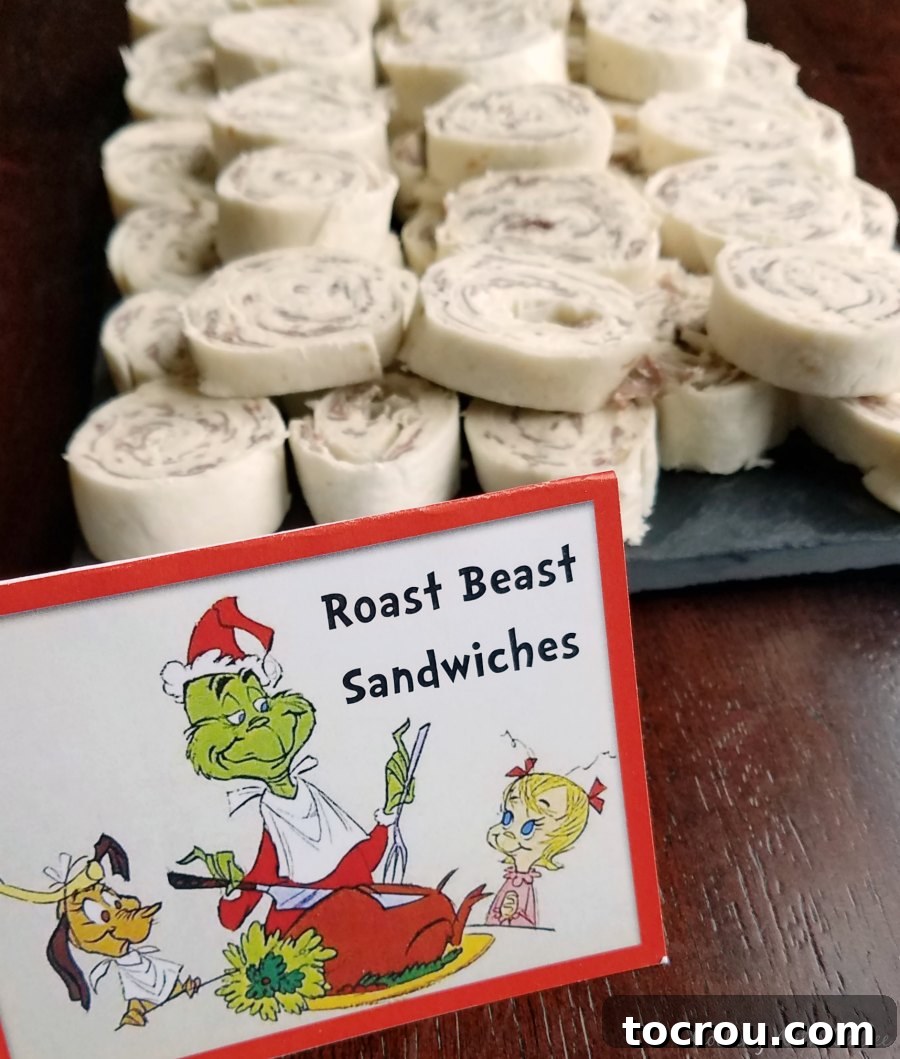 Roast Beast Roll-ups Roast beast roll-ups arranged on a platter next to a Grinch sign, perfect for a Dr. Seuss themed feast.