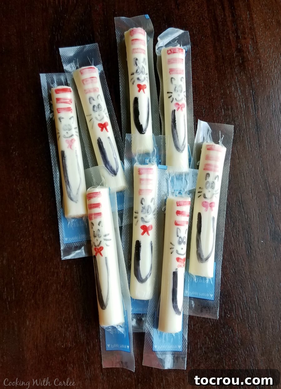 Cat in the Hat Cheese Sticks String cheese sticks with hand-drawn Cat in the Hat faces on their wrappers using a sharpie.