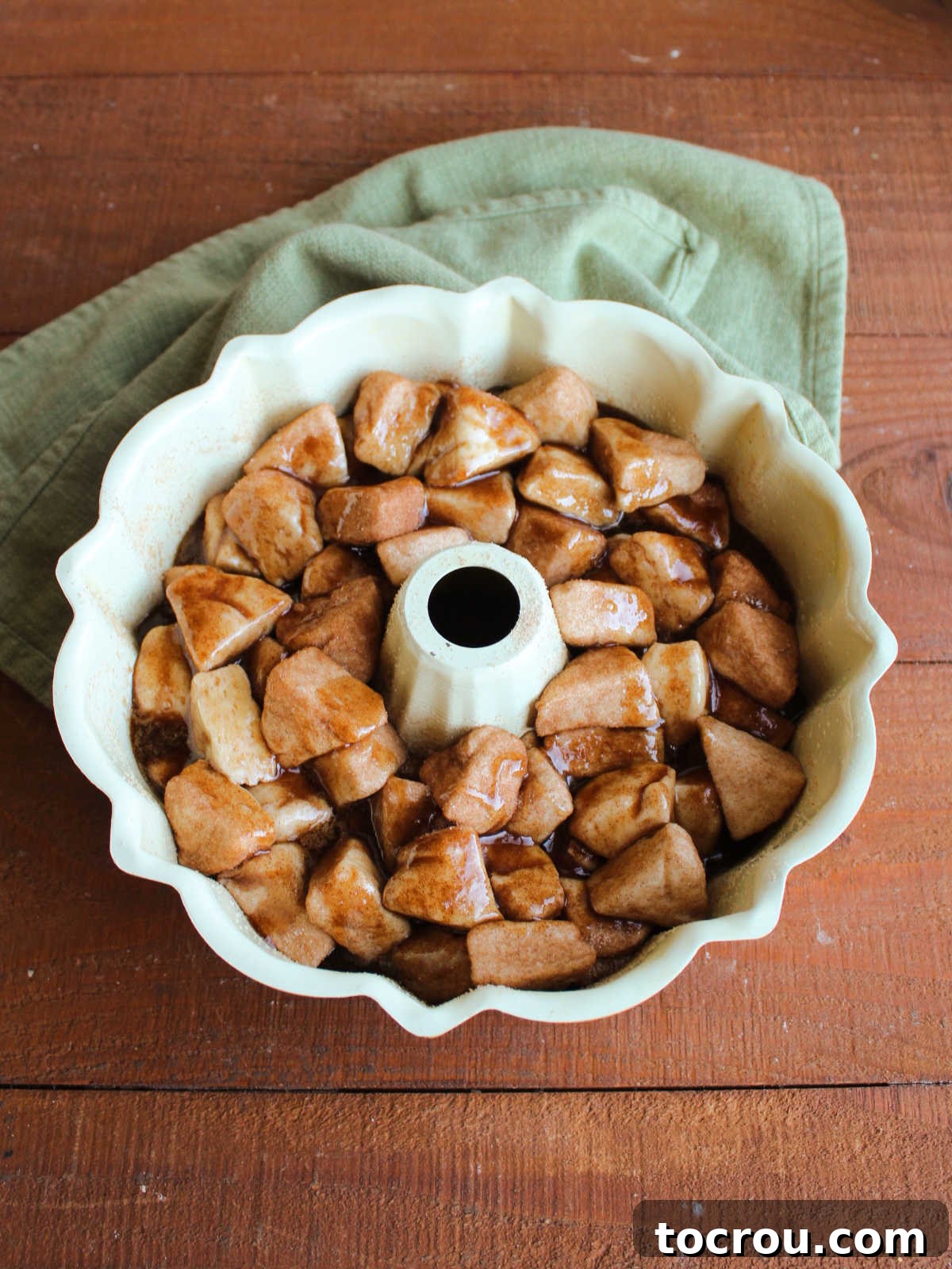 Cinnamon sugar coated biscuits and brown sugar glaze in bundt pan, ready to bake. 