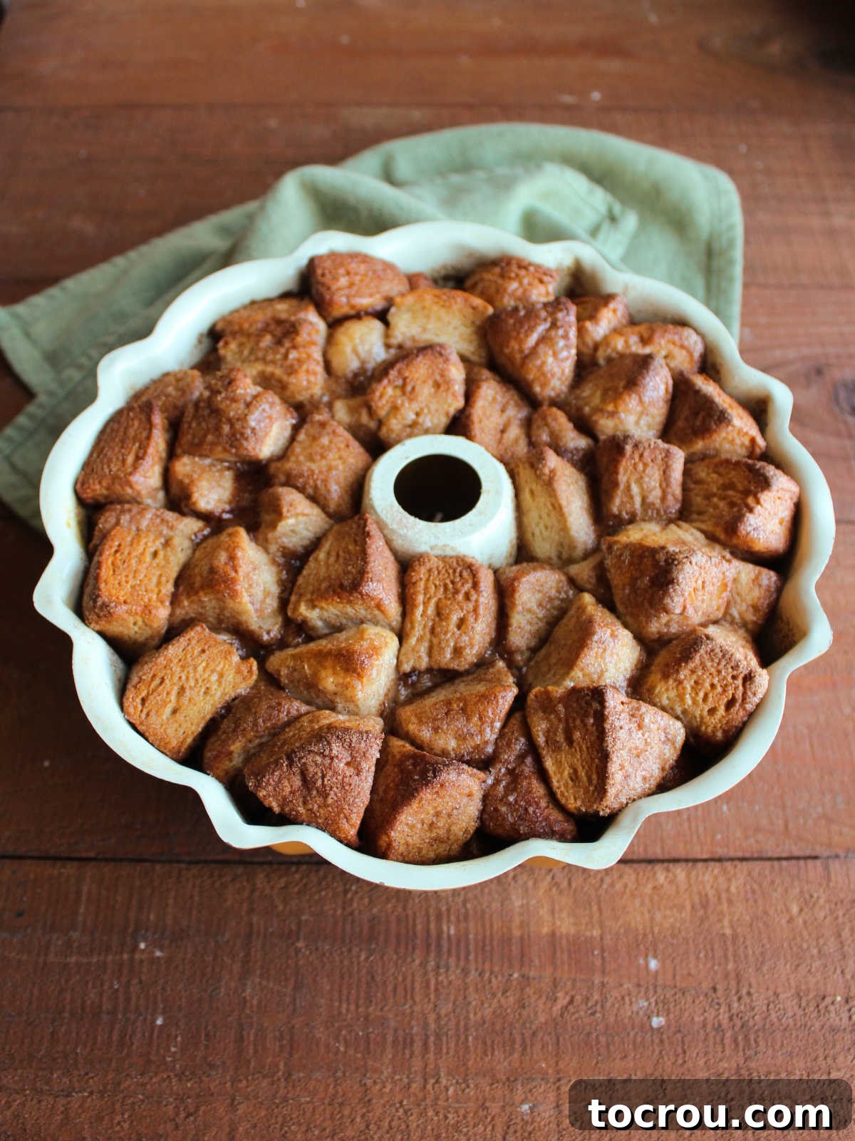 Bundt pan of monkey bread fresh from the oven showing the expanded size and golden brown biscuits. 