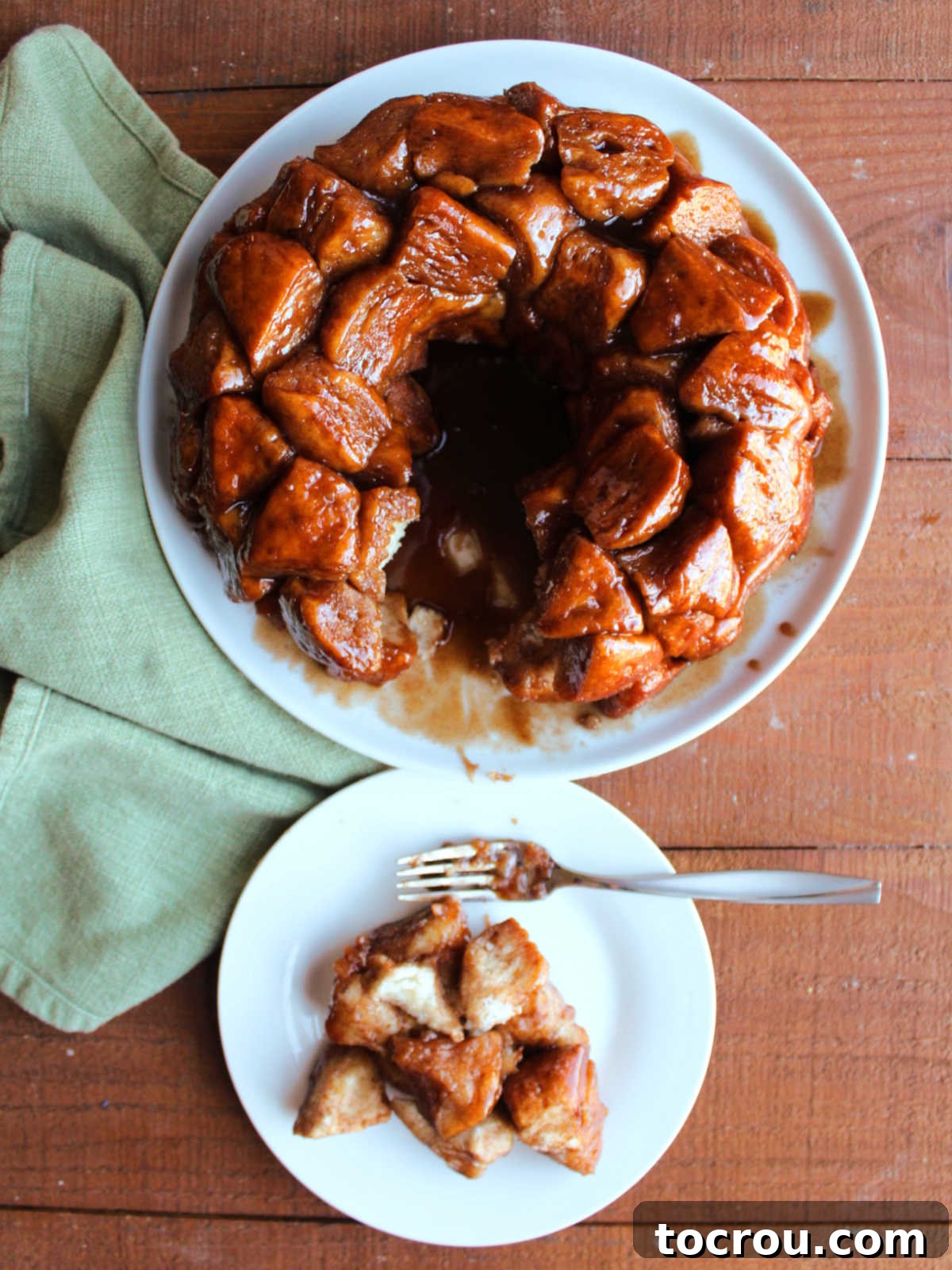 Looking down on a plate with some monkey bread pieces next to the platter with the remaining monkey bread. 