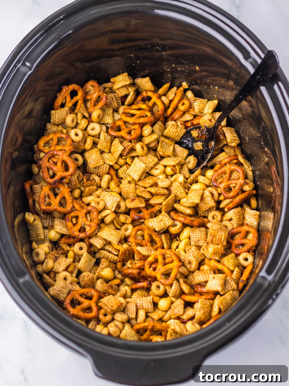 The perfectly toasted and coated sweet Chex mix mixture, glistening with maple cinnamon goodness, after being cooked in the slow cooker.