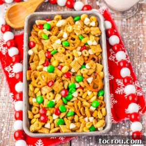 A tray filled with golden-brown Crockpot sweet Chex mix, featuring a delicious maple cinnamon coating, ready to be enjoyed alongside festive holiday candies.