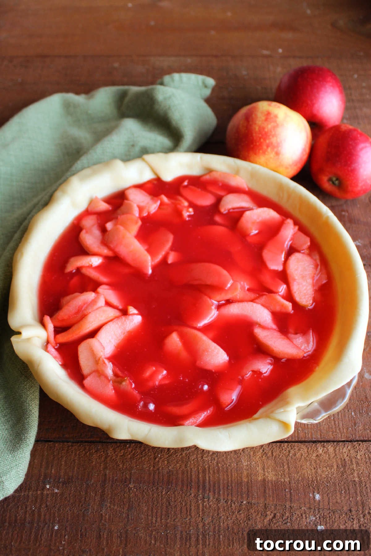 Thickened syrup poured over the apples in the pie crust, ready for the top crust.