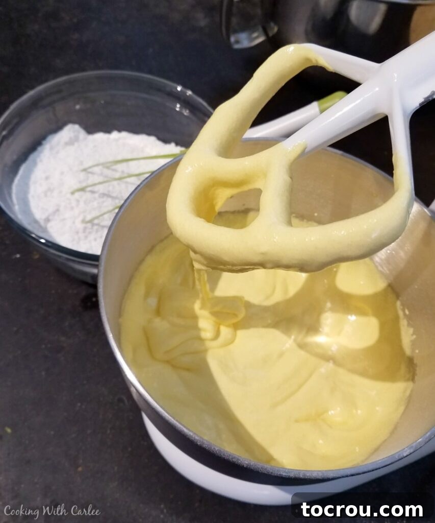 Aerated Egg Yolks and Sugar Creamy, pale yellow mixture of whipped egg yolks and sugar in a stand mixer bowl, highlighting the texture change.
