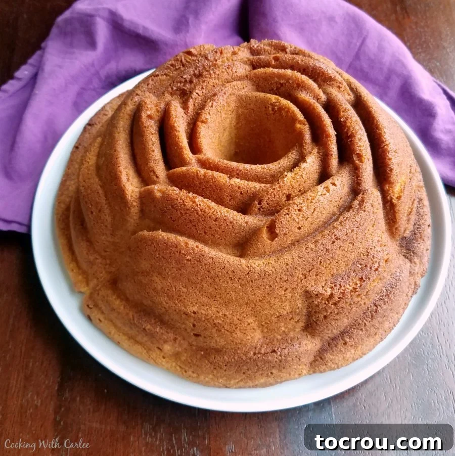 Flower Shaped Golden Bundt Cake A beautifully baked flower-shaped golden Bundt cake on a serving plate, ready for glazing.