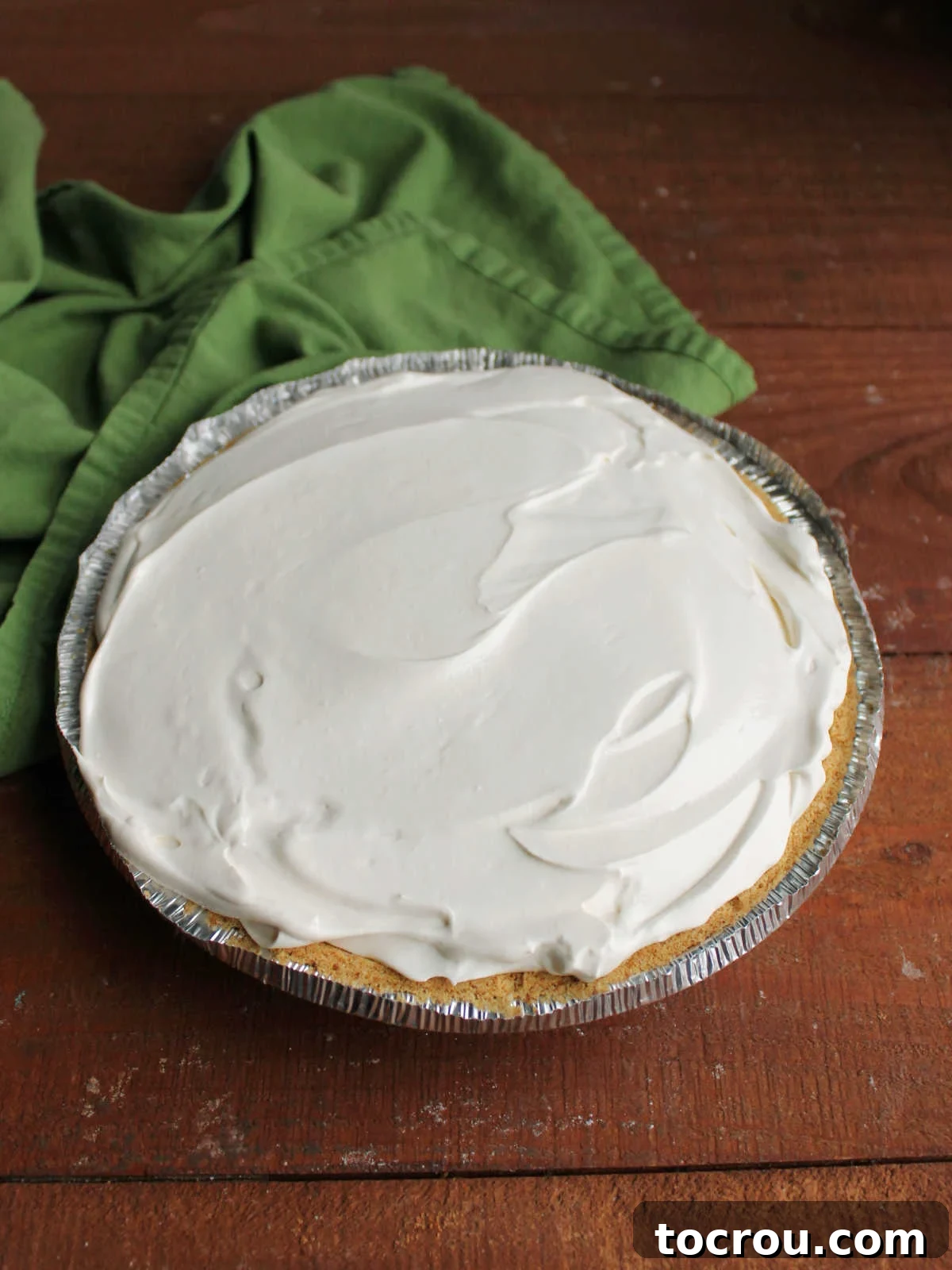 Key Lime Pie Filling in Crust Fluffy, pale green key lime filling, perfectly smoothed into a graham cracker pie crust, ready for chilling or freezing.