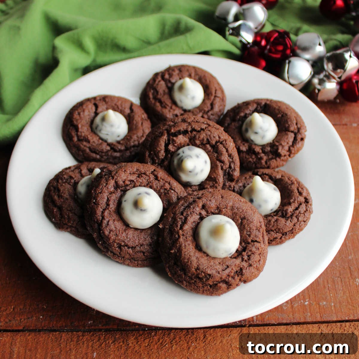 Oreo Dream Blossoms 2 A beautifully arranged plate of freshly baked chocolate cookies, each topped with a distinctive white chocolate Cookies and Cream Hershey's Kiss candy, ready to be enjoyed.