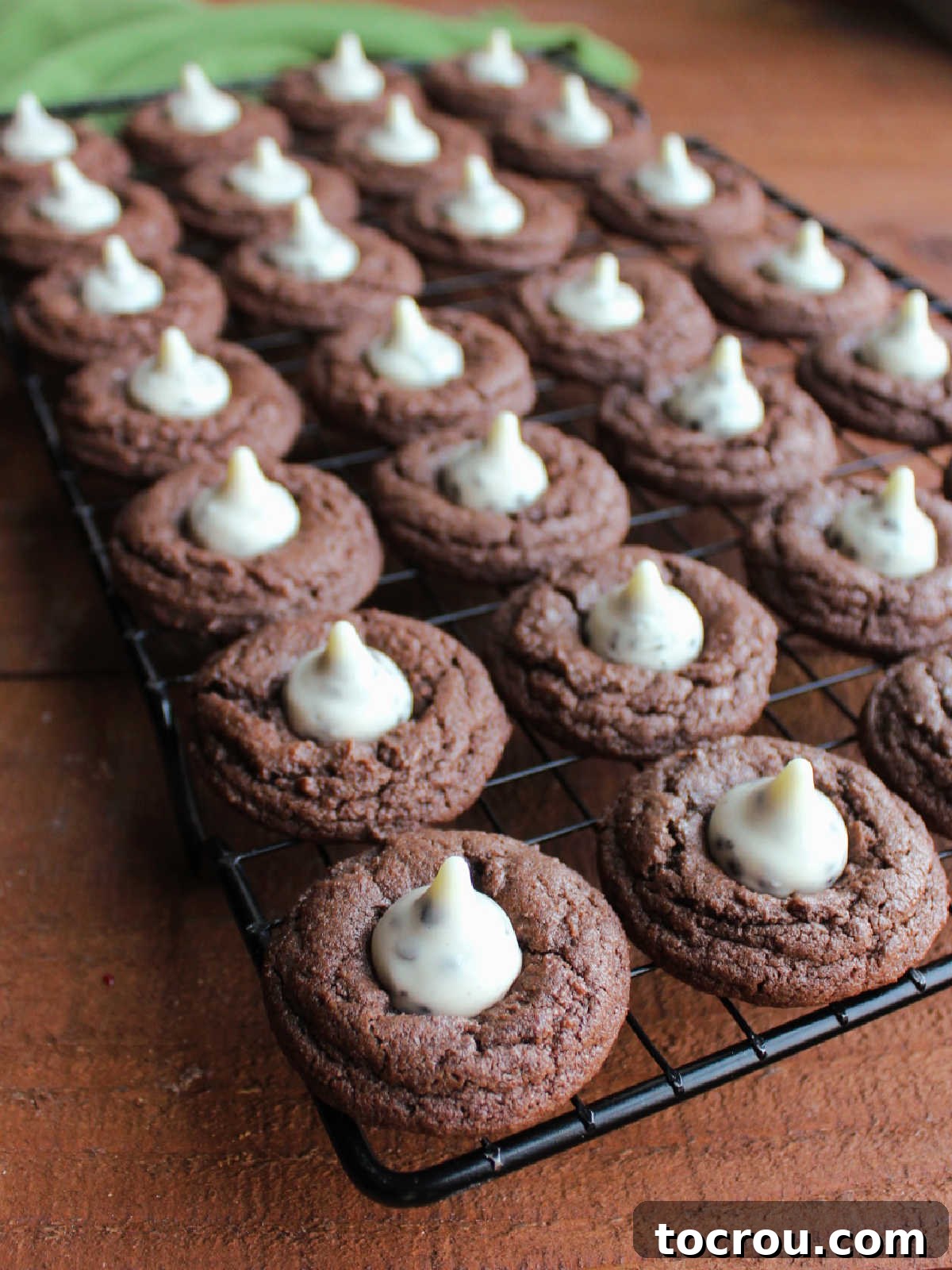 Oreo Dream Blossoms 8 Freshly baked Cookies and Cream Blossom Cookies arranged neatly on a wire cooling rack, allowing them to cool completely and for the Hershey's Kisses to set.