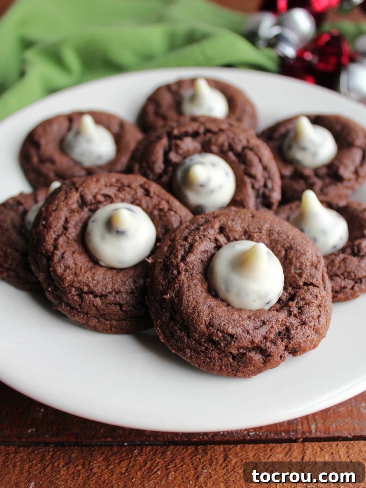 Oreo Dream Blossoms 9 A delightful plate filled with Cookies and Cream Blossom Cookies, showcasing their rich, fudgy chocolate cookie bases beautifully crowned with creamy white chocolate Hershey's Kiss candies.