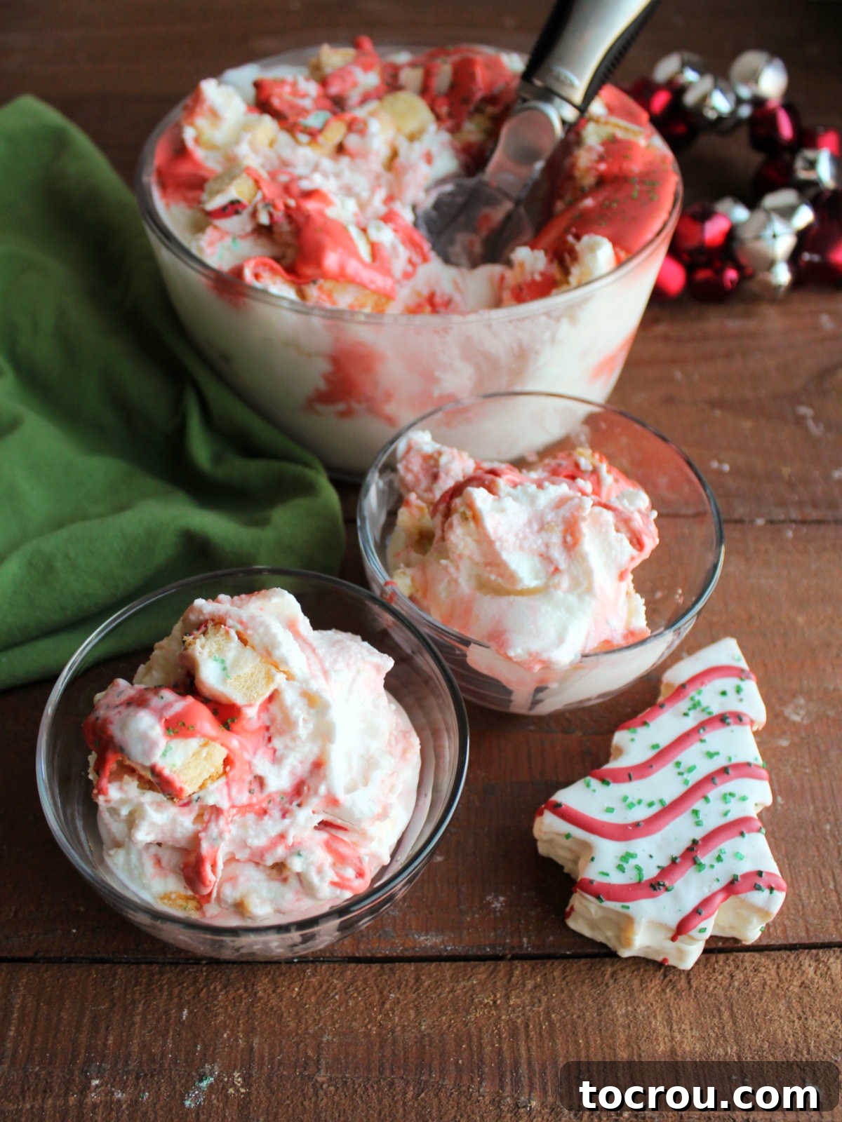 Two small, elegant bowls brimming with homemade Christmas tree ice cream, visibly showcasing the generous bits of snack cake and artistic swirls of marshmallow fluff icing, artfully arranged and ready to be enjoyed as a festive dessert.