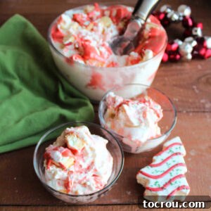 Two small bowls of Christmas tree ice cream with a creamy vanilla base, red buttercream swirls, and generous chunks of the snack cakes inside, presented against a plain background.