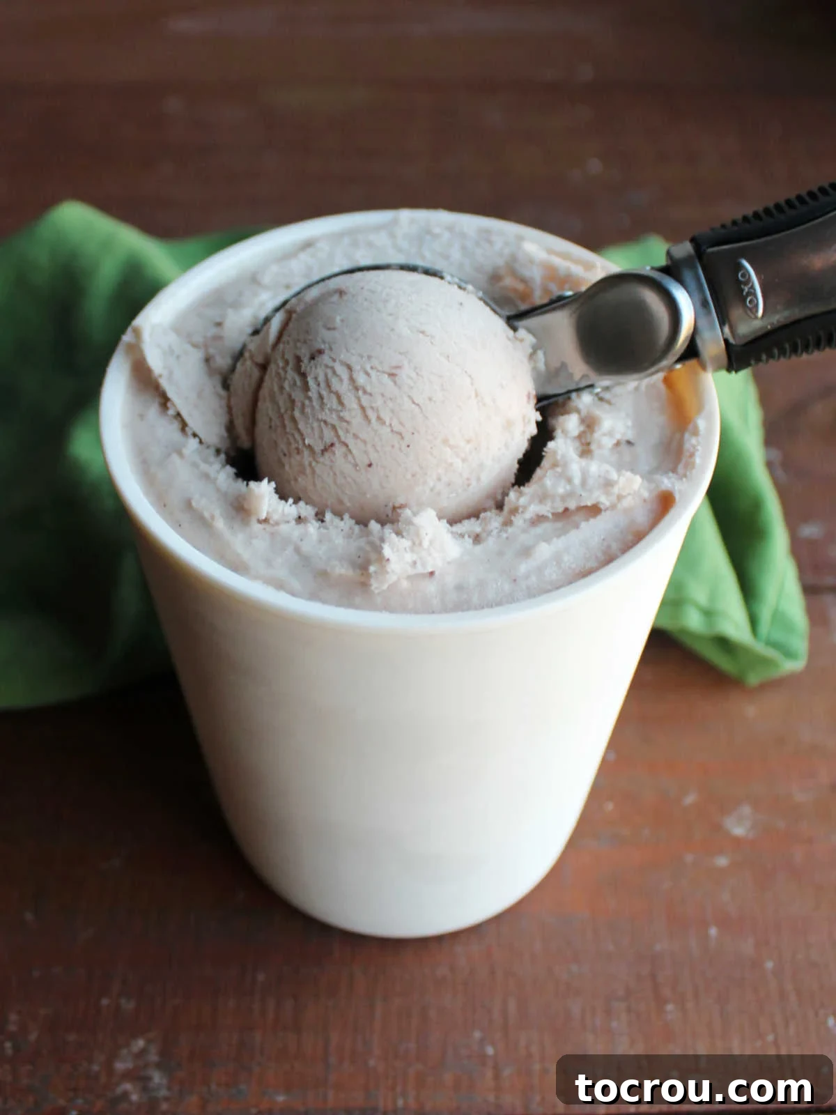 Ice cream scoop getting a ball of frozen homemade apple butter ice cream.
