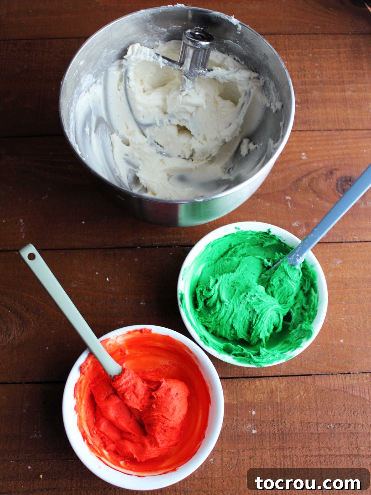 Creamy Dream Mints 4 Mixer bowl with white cream cheese mint mixture next to two smaller bowls, one with red candy and the other with green, ready to be shaped.