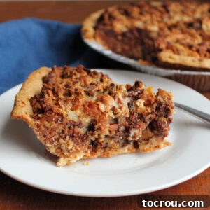 Magic Cookie Bar Pie A mouth-watering slice of Magic Cookie Bar Pie, featuring a golden, flaky pastry crust and a rich, dense filling packed with shredded coconut, crunchy graham crackers, gooey chocolate, sweet caramel, and savory pretzels.