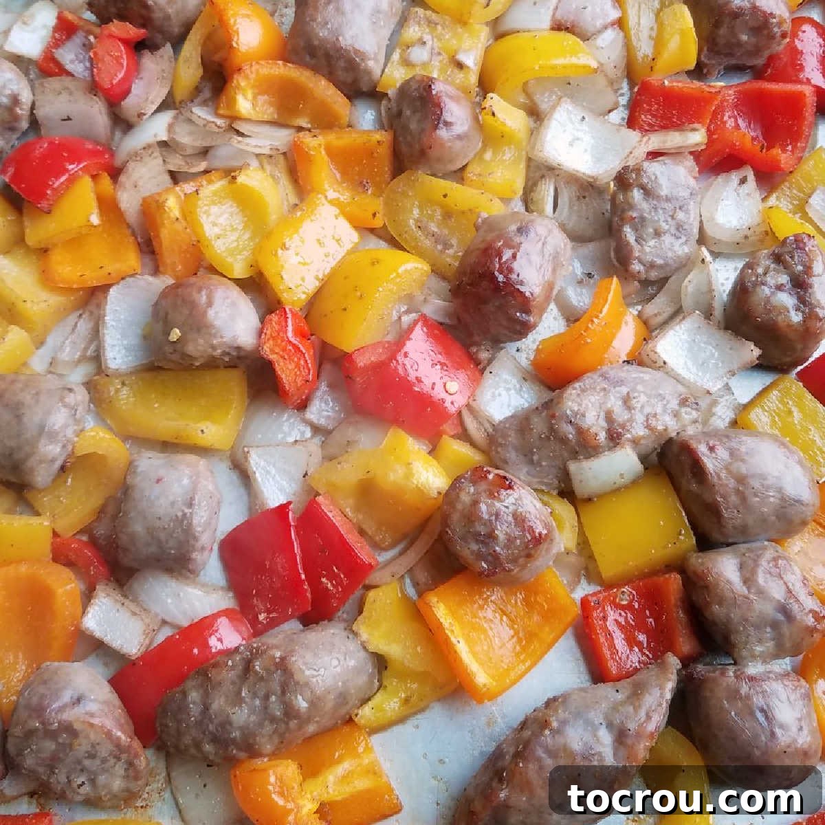 A flavorful and easy sheet pan dinner featuring Italian sausage, peppers, and onions, perfect for busy weeknights. Golden-brown Italian sausage pieces mingled with perfectly roasted onions and vibrant bell peppers, fresh from the oven on a single sheet pan.