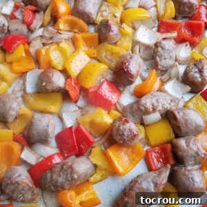 Golden-brown Italian sausage and roasted onions and peppers on a sheet pan, ready to be served.