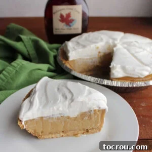 Slice of maple cream pie with graham cracker crust, thick maple custard filling and whipped cream topping, ready to eat.