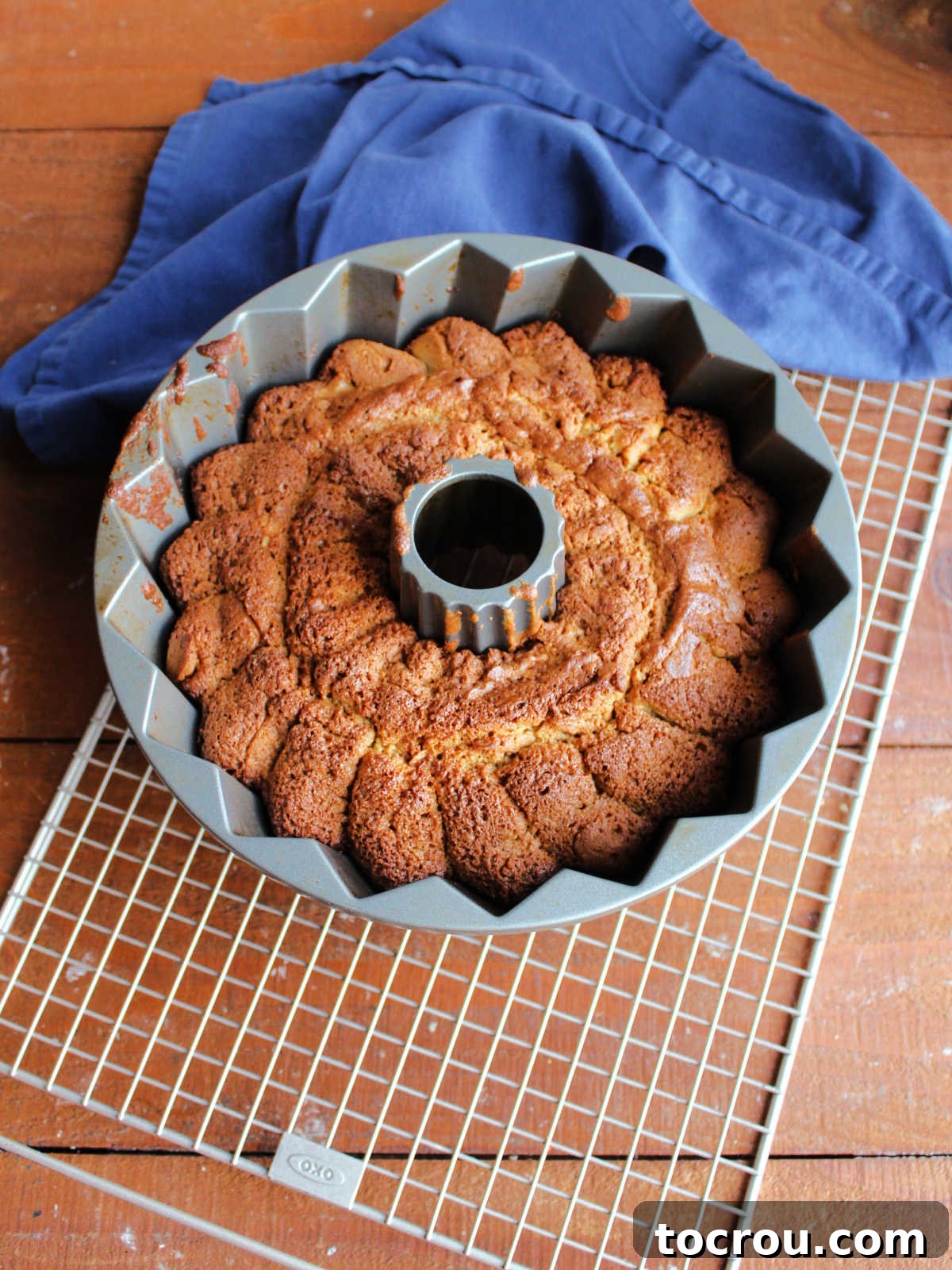 Baked Pound Cake in Pan A Bundt cake pan filled with a freshly baked brown sugar pound cake, sitting on a wire cooling rack, waiting to be inverted.
