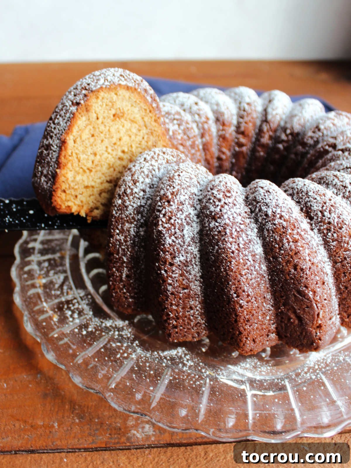First Slice of Pound Cake A knife gently lifts the first perfect slice of brown sugar pound cake, revealing its inviting tan color and soft, dense texture.