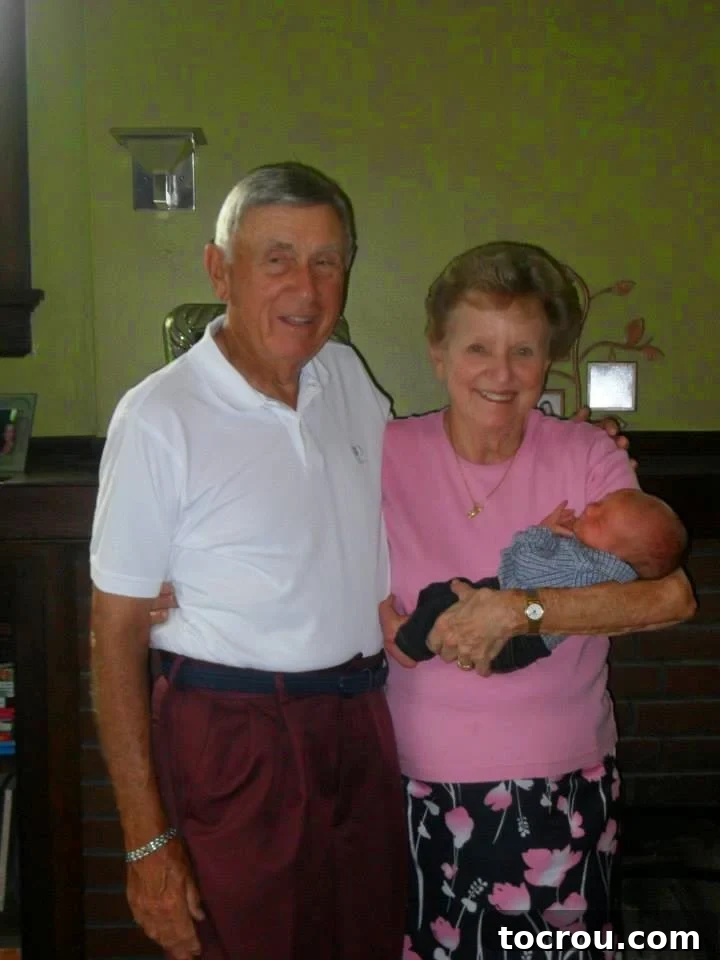 A heartwarming photograph of Paw-Paw and Maw-Maw, smiling as they lovingly hold their baby grandson, Little Dude.