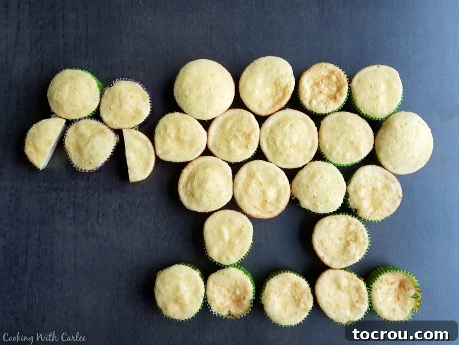 Cupcakes meticulously arranged on a platter to form the shape of a lamb's body and head, ready for frosting.