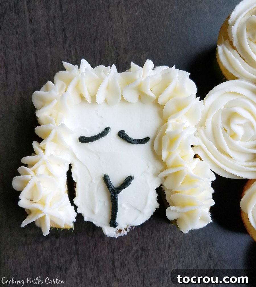 Close-up of the finished lamb face on the cupcake cake, featuring black frosting for eyes, nose, and mouth for an expressive look.