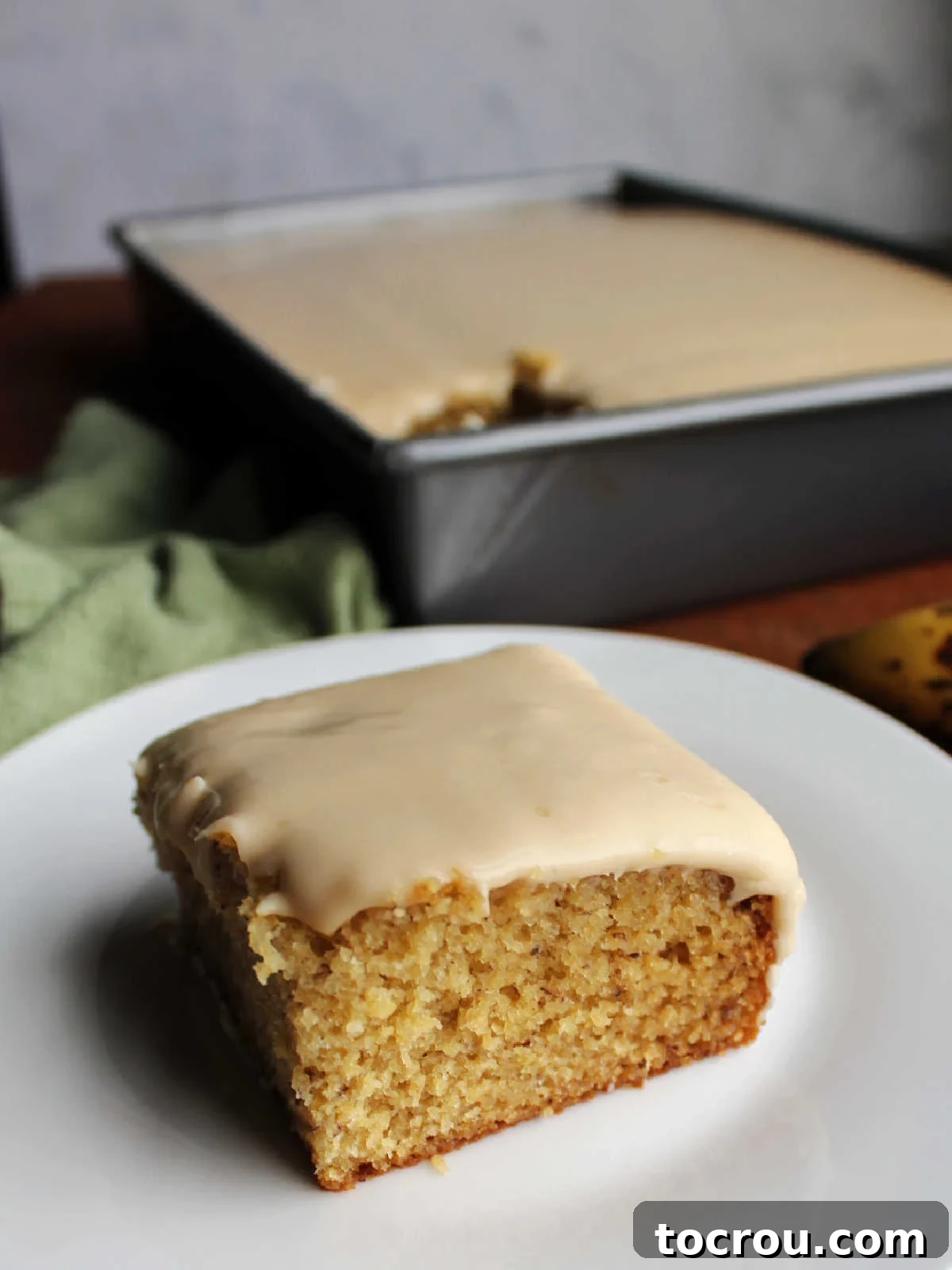 Golden Banana Cake Crowned with Brown Sugar Glaze 3 Piece of moist banana cake topped with penuche icing, ready to eat.