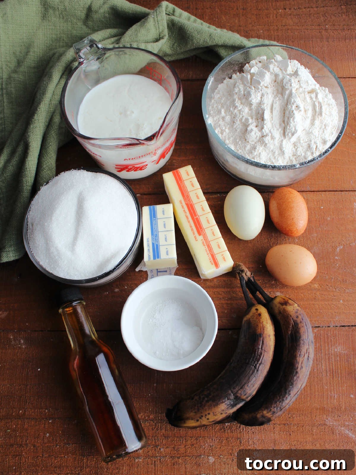 Golden Banana Cake Crowned with Brown Sugar Glaze 4 Ingredients including ripe bananas, flour, sugar, butter, vanilla, eggs, soured milk, and baking powder ready to be made into a cake.