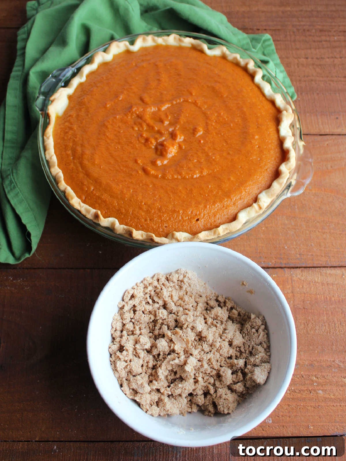 Spiced Carrot Pie with Crunchy Cinnamon Streusel 8 Partially baked carrot pie next to bowl filled with cinnamon, flour, sugar and butter streusel mixture ready to go on the pie.