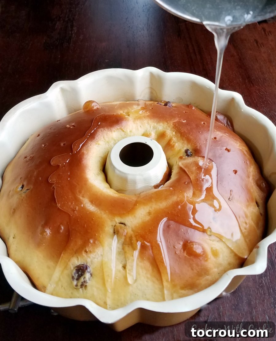 Drizzling sugar syrup over warm babka still in pan.
