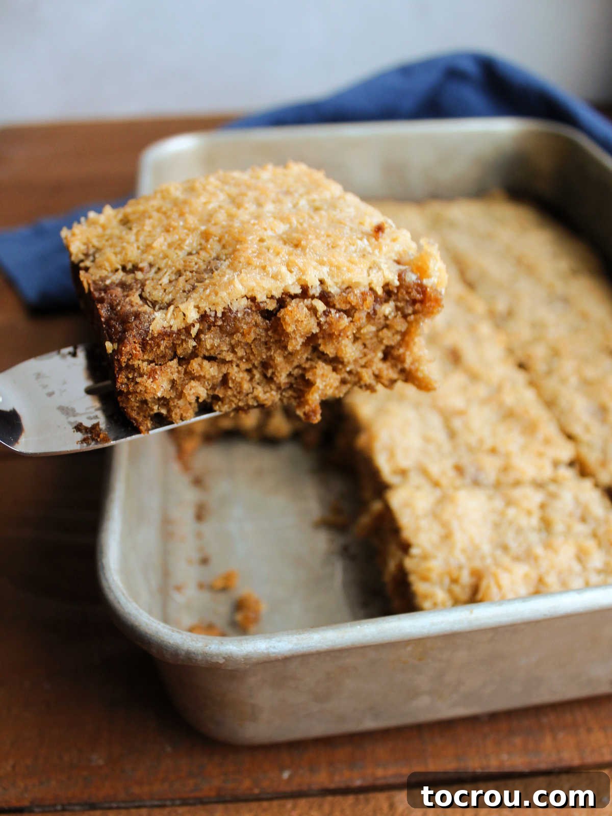 Spatula lifting a piece of oatmeal cake out of the pan. 