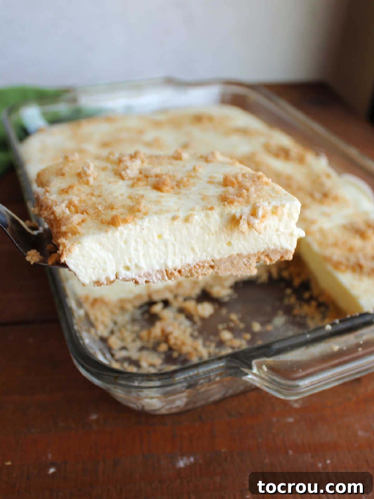 Spatula lifting square of woolworth cheesecake out of pan.