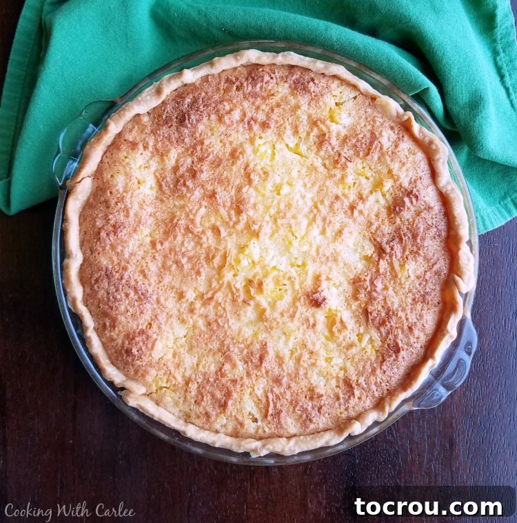 A whole, freshly baked golden-brown tropical pie, straight from the oven, ready to cool and be enjoyed.