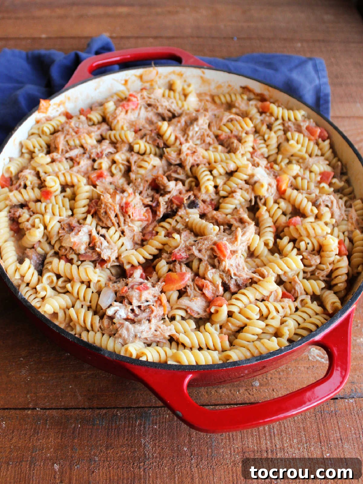 Velvety BBQ Pulled Pork Pasta 4 Cooked rotini pasta stirred into pork mixture in cast iron pan.