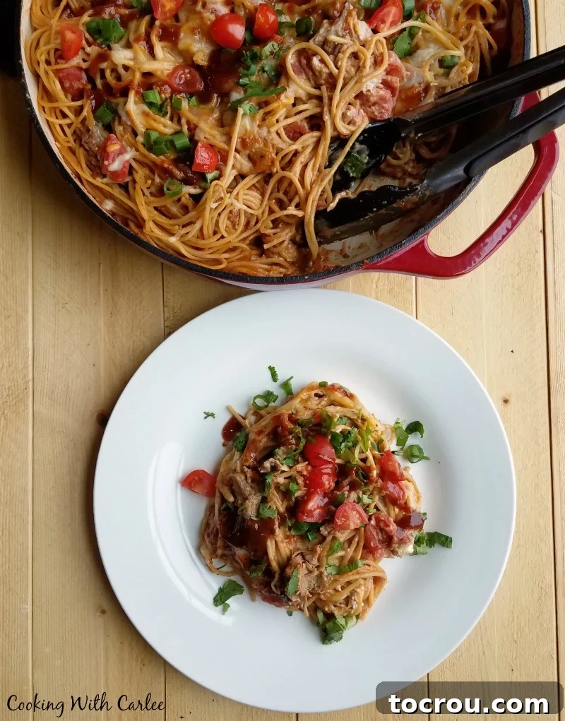 Velvety BBQ Pulled Pork Pasta 7 Plate with bbq pulled pork spaghetti next to the pan it was cooked in and more creamy pork pasta.
