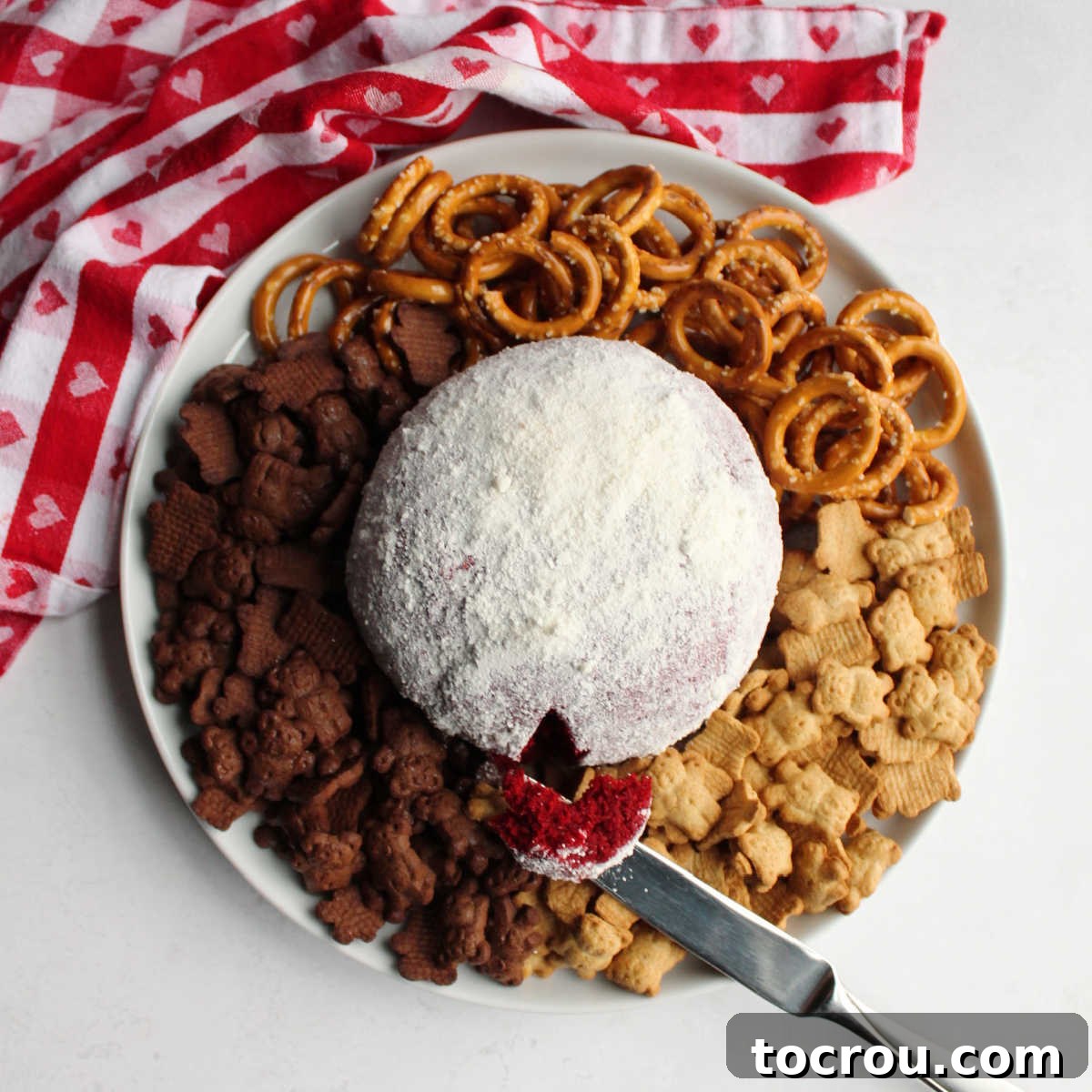 Red Velvet Cheesecake Ball 4 looking down on platter filled with white chocolate covered red velvet cheese ball and dippers