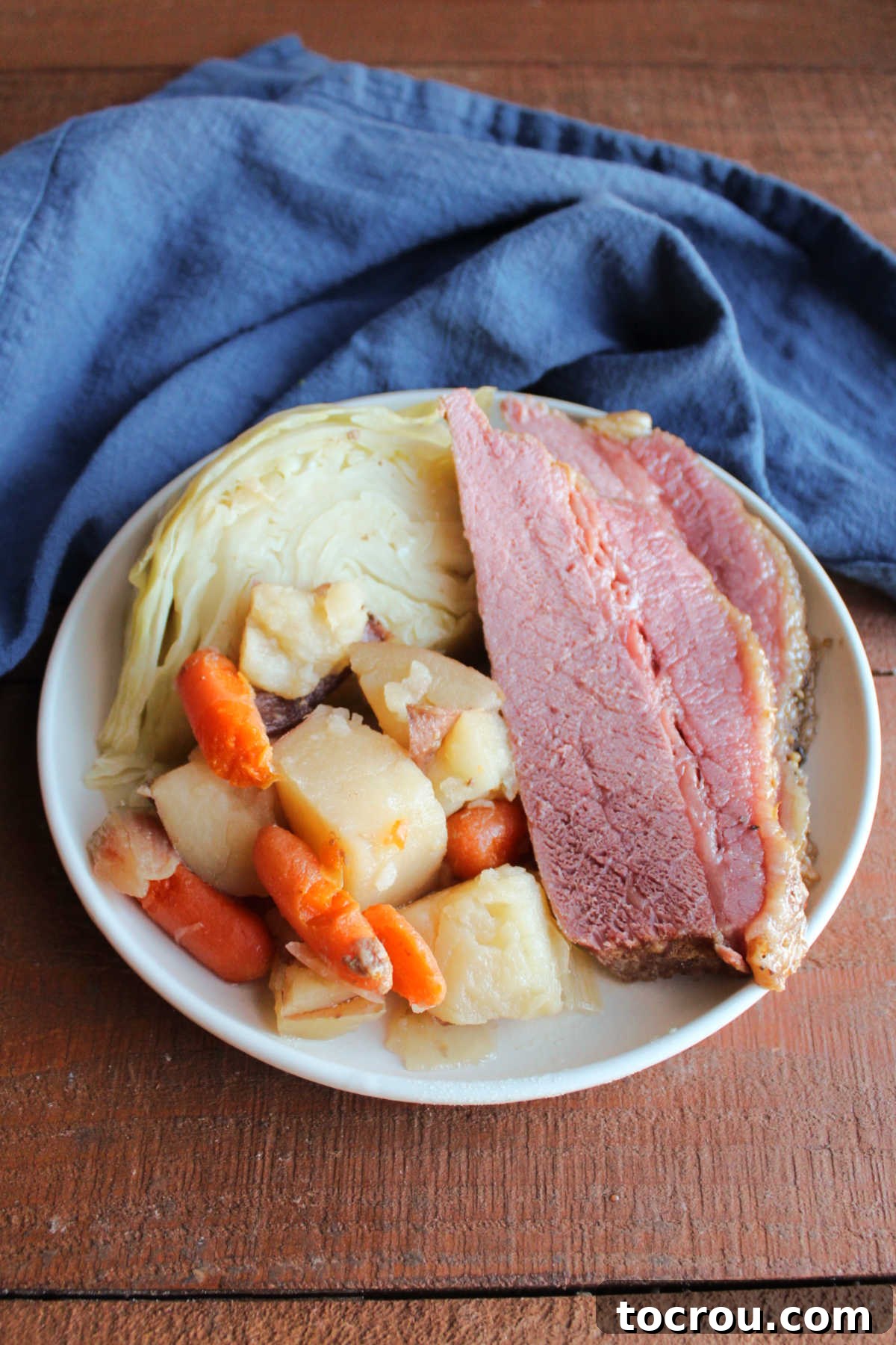 Plate with corned beef, cabbage, potatoes, and carrots, ready to eat. 