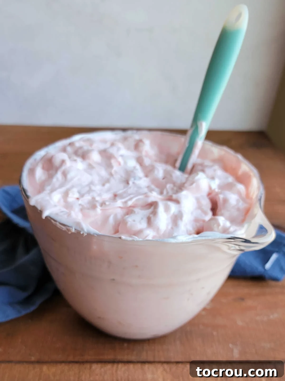 Glass mixing bowl after the Cool Whip has been stirred in with the cherries, pineapple, sweetened condensed milk, and marshmallows. 