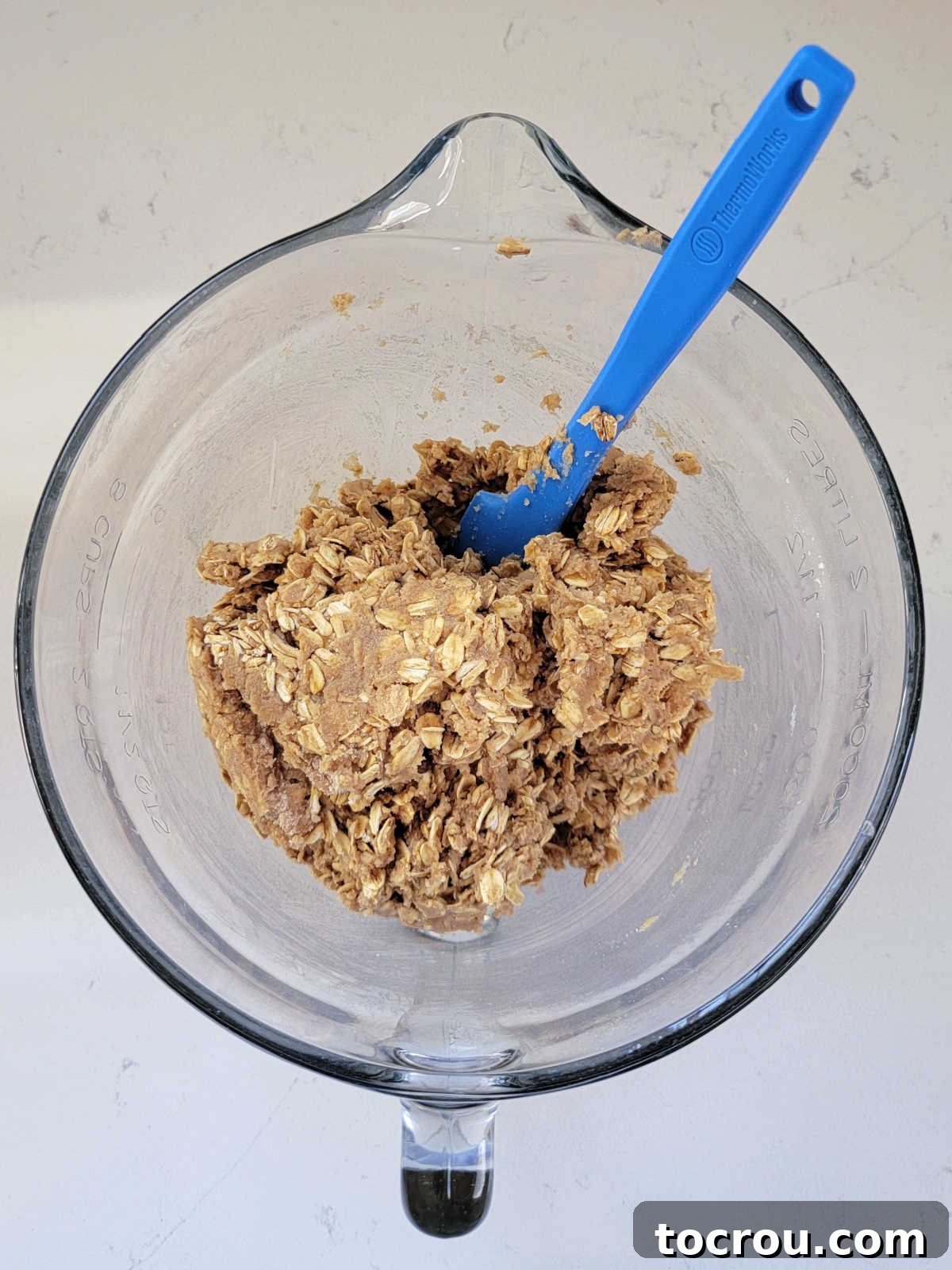Thick sourdough, oat, and whole wheat dough mixing in a bowl, ready for baking into bars.