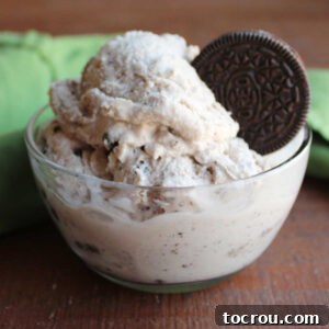 Small glass bowl filled with a couple of scoops of homemade cookies and cream ice cream garnished with an Oreo, ready to eat.