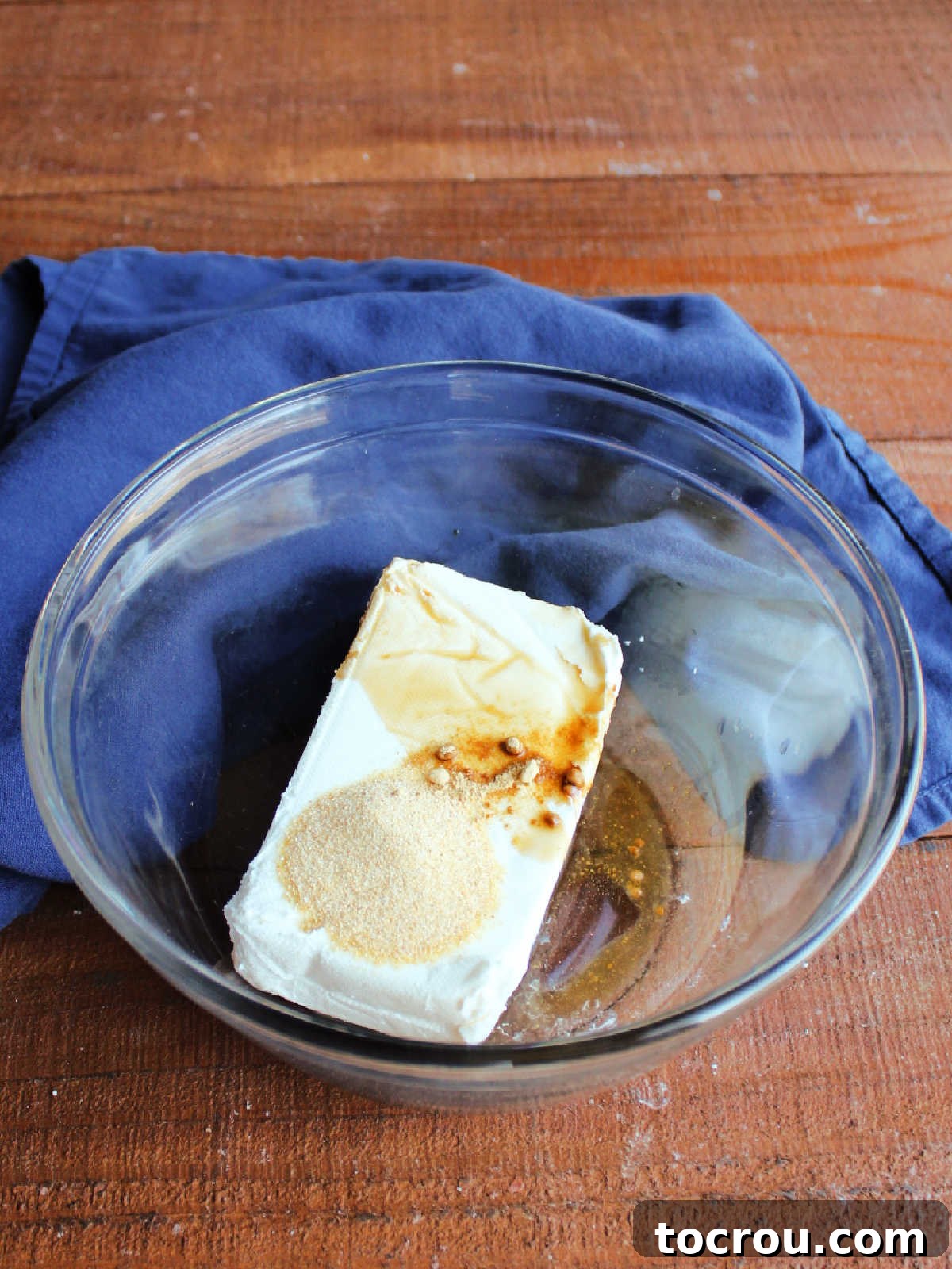 Ingredients for Crab Rangoon Filling Mixing bowl with softened cream cheese, Worcestershire sauce, garlic powder, lemon juice, ground ginger, and salt, ready to be combined for the crab rangoon filling.