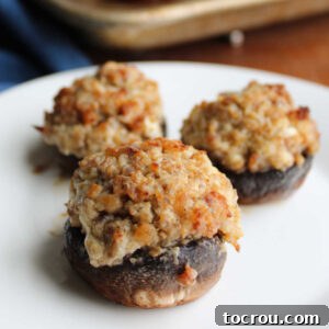 Close up of baked stuffed mushrooms with sausage and cream cheese filling.