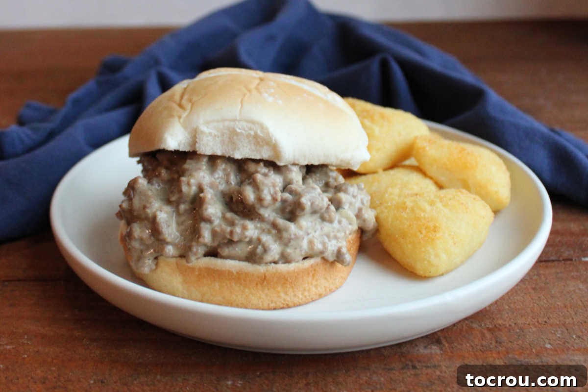 Dinner plate with creamy Davy Crockett sandwich filling on bun served with heart shaped potato puffs. A perfect quick family meal.