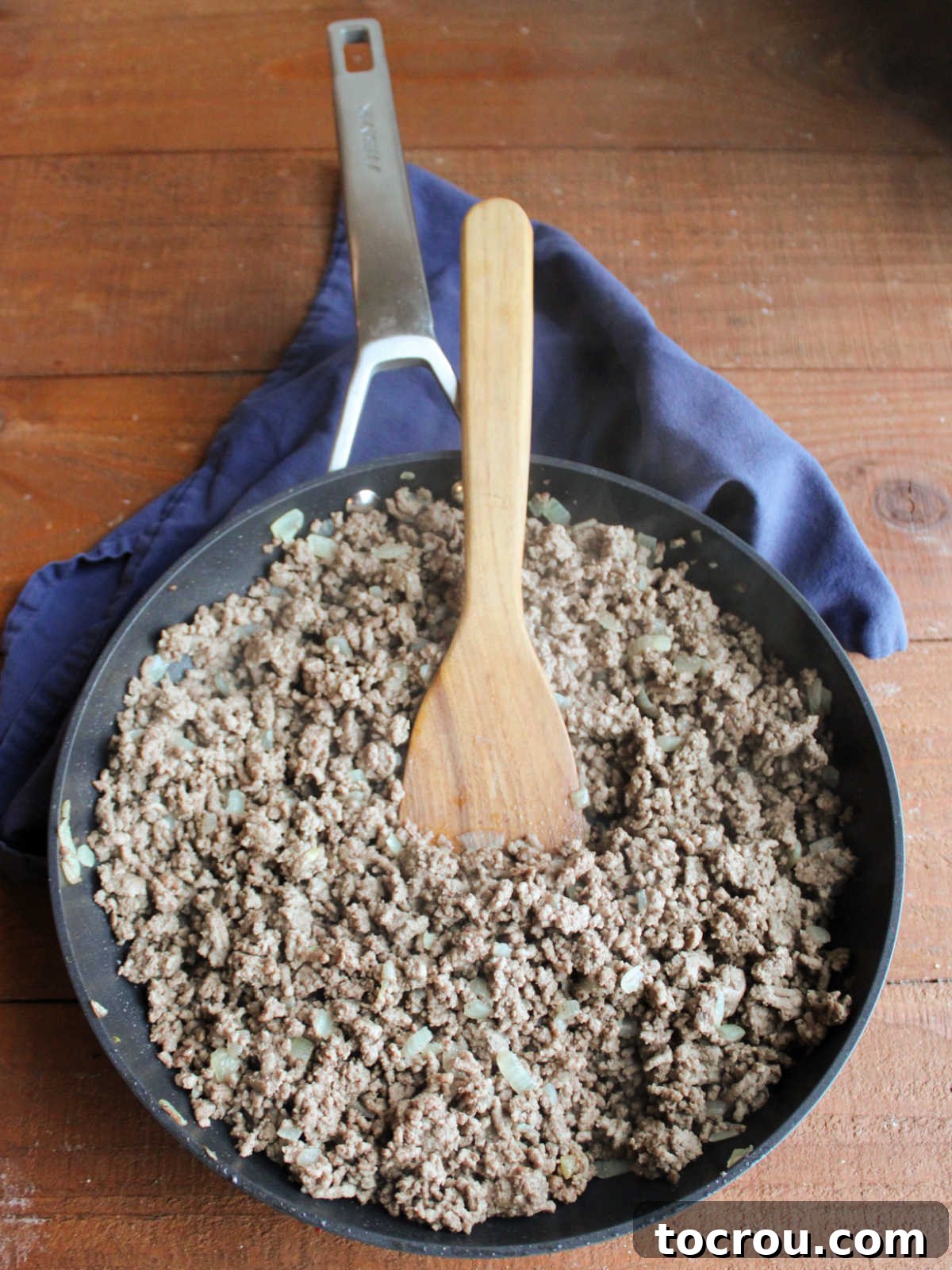 Skillet showing browned ground beef and diced onion mixture, perfectly cooked and ready for the rich, creamy sauce. A key step for delicious Davy Crockett Sandwiches.